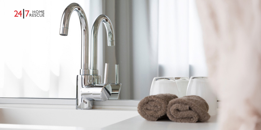 Water tap in a bathroom with towels
