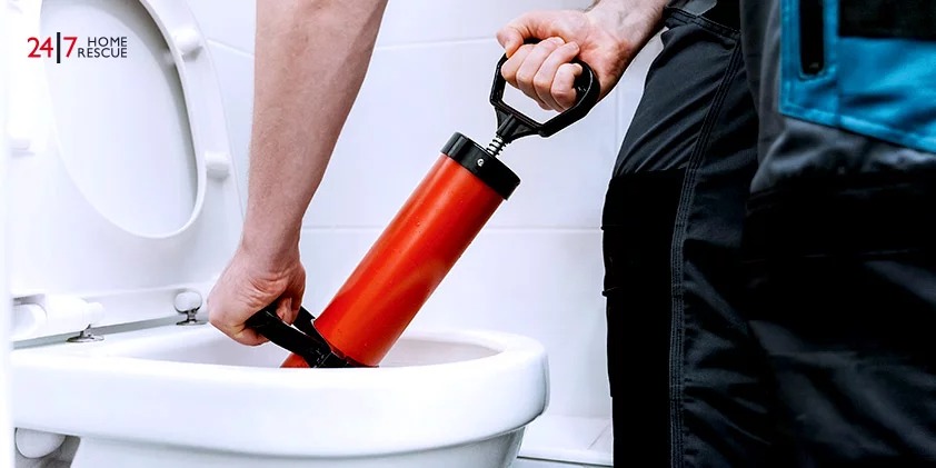 A plumber unclogs toilets with a professional force pump cleaner