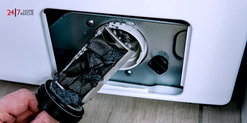 A Male Hand Removes a Dirty and Clogged Washing Machine Pump Filter