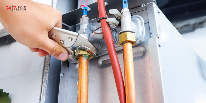 Engineer repairing gas boiler in home