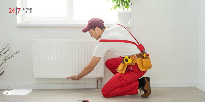 Technician repairing a heating radiator with a wrench