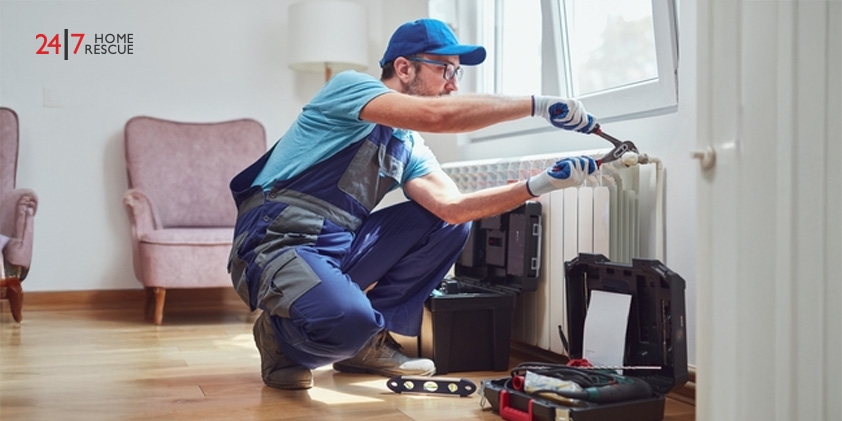 Technician fixing a home radiator during seasonal heating problems