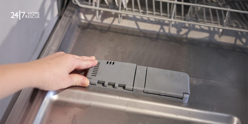 woman loading a dishwasher with its door open while doing household chores