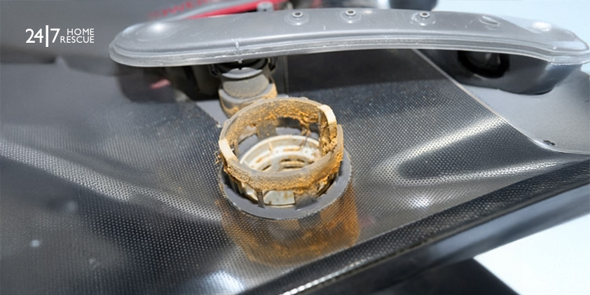 A dishwasher filter in the kitchen clogged with food scraps