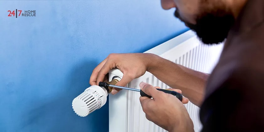 Close-up Of A Young Male heating engineer replacing the thermostatic radiator valve