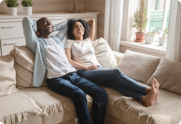 A happy husband and wife lying on a comfortable couch, enjoying peace of mind