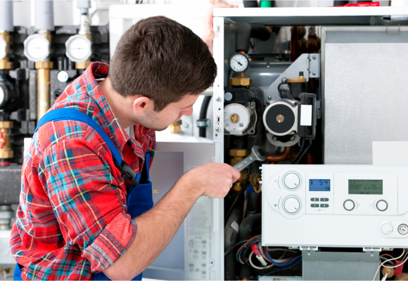 An engineer is servicing the gas boiler for hot water and heating