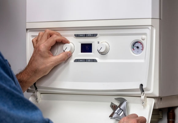 A gas safe engineer repairing a home central heating system boiler