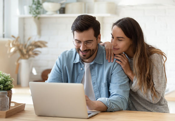 Loving couple using laptop and doing online shopping