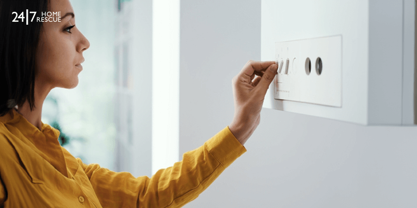 A woman is turning on the boiler