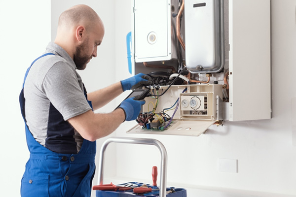 Qualified engineer checking flue gas emissions on a domestic gas boiler using a flue gas analyzer