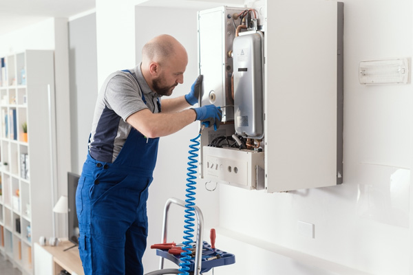 Gas engineer inspecting a boiler at home.