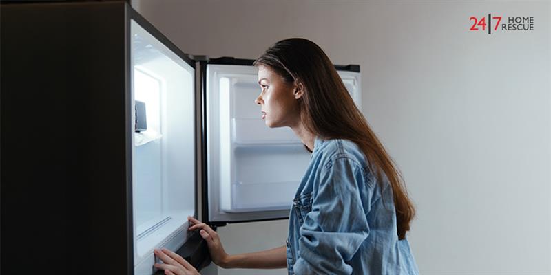 Woman inspecting a freezer that is not freezing properly
