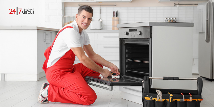 Young man repairing oven in kitchen