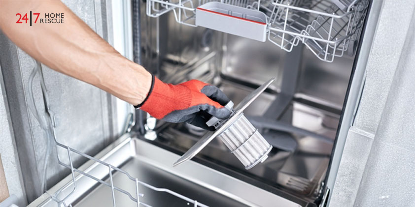 Technician cleaning a clogged filter in the dishwasher