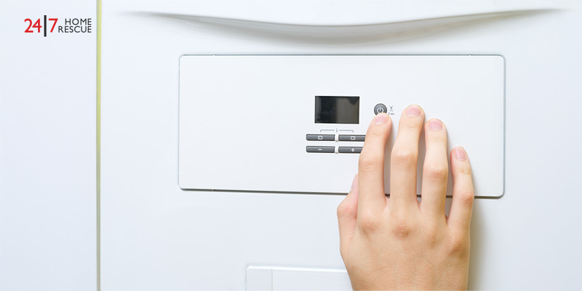 Hand on boiler control panel with digital display and buttons