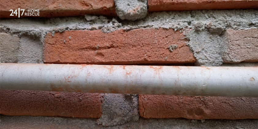 brick wall background with pipes hanging on the wall