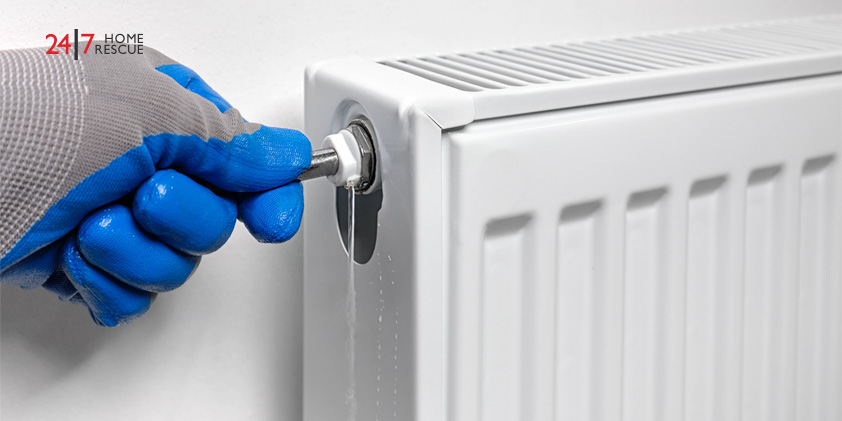 Engineer bleeding a gas boilers radiator