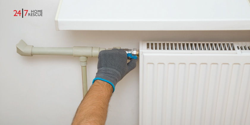 Engineer solving airlock of a gas boiler radiator