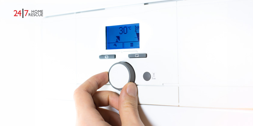 Person adjusting the temperature of a gas boiler