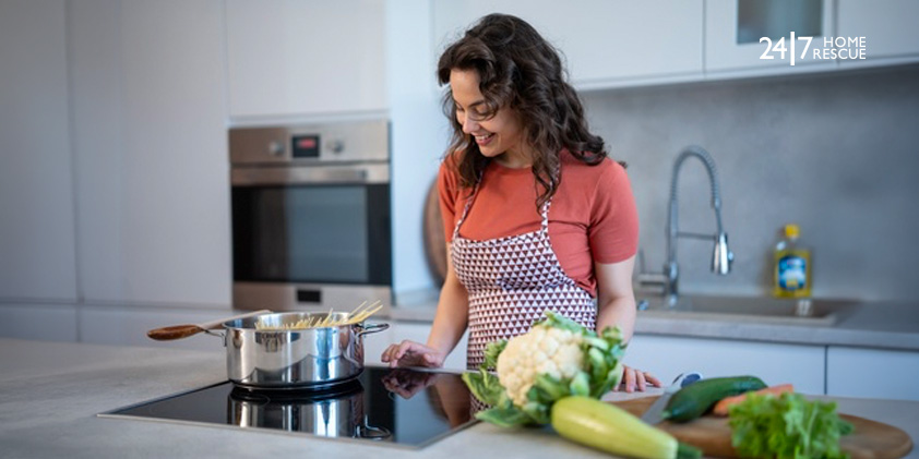A woman cooking in a modern kitchen while using the touch controls on an induction hob.